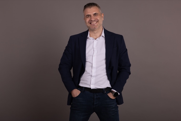 Portret editorial Marius Dosinescu în sacou, în picioare
